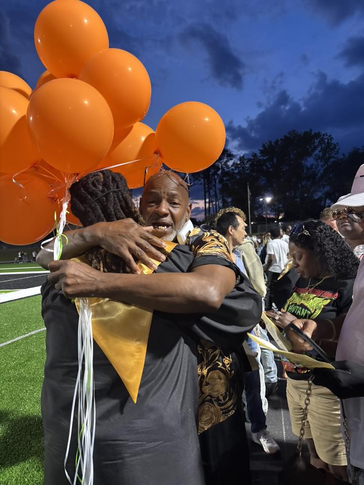 Kencerio Walker and James Walker hugging, during his graduation on May 22, 2026 | Source: Facebook/Lisa Kennedy