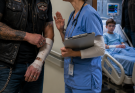 Biker Waiting for Stitches Froze When a Nurse Quietly Whispered, “Please Check Room 214” — Until He Realized Why a Terrified Little Boy Refused to Go Home